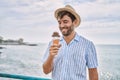 Young hispanic man smiling happy eating ice cream at the beach Royalty Free Stock Photo