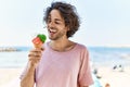 Young hispanic man smiling happy eating ice cream at the beach Royalty Free Stock Photo