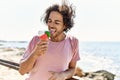 Young hispanic man smiling happy eating ice cream at the beach Royalty Free Stock Photo