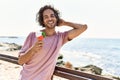 Young hispanic man smiling happy eating ice cream at the beach Royalty Free Stock Photo