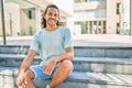 Young hispanic man smiling happy looking to the camera and sitting on the stairs Royalty Free Stock Photo