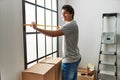 Young hispanic man smiling happy moving at new home Royalty Free Stock Photo