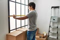 Young hispanic man smiling happy moving at new home Royalty Free Stock Photo