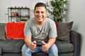 Young hispanic man smiling happy playing video game at home Royalty Free Stock Photo