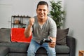 Young hispanic man smiling happy playing video game at home Royalty Free Stock Photo