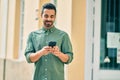 Young hispanic man smiling happy using smartphone at the city Royalty Free Stock Photo