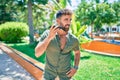 Young hispanic man smiling happy using smartphone walking at the park Royalty Free Stock Photo