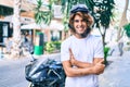 Young hispanic man smiling happy wearing moto helmet over motorcycle at the city