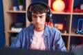 Young hispanic man streamer playing video game using computer at gaming room Royalty Free Stock Photo