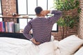 Young hispanic man suffering for back injury sitting on bed at bedroom Royalty Free Stock Photo