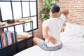 Young hispanic man suffering for back injury sitting on bed at bedroom Royalty Free Stock Photo