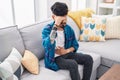 Young hispanic man suffering for stomache ache sitting on sofa at home Royalty Free Stock Photo