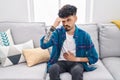 Young hispanic man suffering for stomache ache sitting on sofa at home Royalty Free Stock Photo