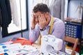 Young hispanic man tailor stressed working at tailor shop