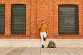 A young Hispanic man talking on his smart phone, on a street outdoors. lifestyle concept. yellow and vivid colors Royalty Free Stock Photo