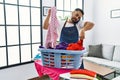 Young hispanic man talking on the smartphone while doing chores at home Royalty Free Stock Photo