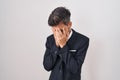 Young hispanic man with tattoos wearing business suit and tie with sad expression covering face with hands while crying Royalty Free Stock Photo