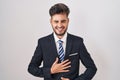 Young hispanic man with tattoos wearing business suit and tie smiling and laughing hard out loud because funny crazy joke with Royalty Free Stock Photo