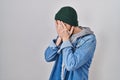 Young hispanic man with tattoos wearing wool cap with sad expression covering face with hands while crying Royalty Free Stock Photo