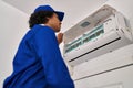 Young hispanic man technician repairing air conditioning at home Royalty Free Stock Photo
