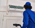 Young hispanic man technician repairing air conditioning at home Royalty Free Stock Photo