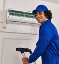 Young hispanic man technician repairing air conditioning at home Royalty Free Stock Photo
