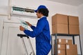 Young hispanic man technician repairing air conditioning at office Royalty Free Stock Photo