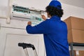 Young hispanic man technician repairing air conditioning at office Royalty Free Stock Photo