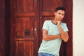 Young Hispanic man thinking with crossed hands against the door and white wall Royalty Free Stock Photo