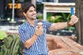 Young hispanic man tourist making selfie by smartphone eating ice cream at park Royalty Free Stock Photo