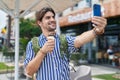 Young hispanic man tourist making selfie by smartphone eating ice cream at street Royalty Free Stock Photo