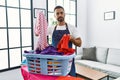 Young hispanic man unhappy doing chores at home Royalty Free Stock Photo