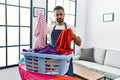 Young hispanic man unhappy doing chores at home Royalty Free Stock Photo