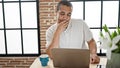 Young hispanic man using laptop sitting on table at dinning room Royalty Free Stock Photo