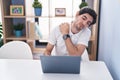 Young hispanic man using laptop suffering for bachache at home Royalty Free Stock Photo