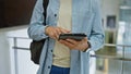 Young hispanic man using tablet indoors at a university library Royalty Free Stock Photo