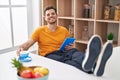 Young hispanic man using touchpad drinkng coffee at home