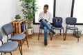 Young hispanic man waiting filling documents on clipboard at waiting room Royalty Free Stock Photo