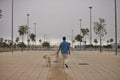 Young Hispanic man, walking his dog on the street in solitude seen from the back. Concept, dogs, pets, animals, friends