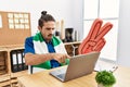 Young hispanic man watching football on laptop cheering game at the office pointing with finger to the camera and to you, Royalty Free Stock Photo