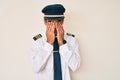 Young hispanic man wearing airplane pilot uniform rubbing eyes for fatigue and headache, sleepy and tired expression Royalty Free Stock Photo