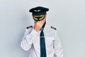 Young hispanic man wearing airplane pilot uniform tired rubbing nose and eyes feeling fatigue and headache Royalty Free Stock Photo