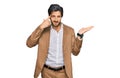 Young hispanic man wearing business clothes confused and annoyed with open palm showing copy space and pointing finger to forehead Royalty Free Stock Photo