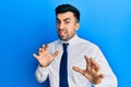 Young hispanic man wearing business clothes disgusted expression, displeased and fearful doing disgust face because aversion Royalty Free Stock Photo