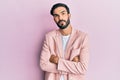 Young hispanic man wearing business jacket skeptic and nervous, disapproving expression on face with crossed arms Royalty Free Stock Photo