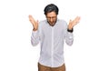 Young hispanic man wearing business shirt and glasses celebrating mad and crazy for success with arms raised and closed eyes Royalty Free Stock Photo