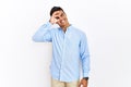 Young hispanic man wearing business shirt standing over isolated background doing ok gesture with hand smiling, eye looking Royalty Free Stock Photo