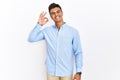 Young hispanic man wearing business shirt standing over isolated background smiling positive doing ok sign with hand and fingers Royalty Free Stock Photo