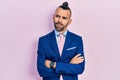 Young hispanic man wearing business suit with arms crossed gesture angry and mad screaming frustrated and furious, shouting with Royalty Free Stock Photo