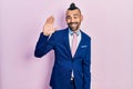Young hispanic man wearing business suit and tie waiving saying hello happy and smiling, friendly welcome gesture Royalty Free Stock Photo